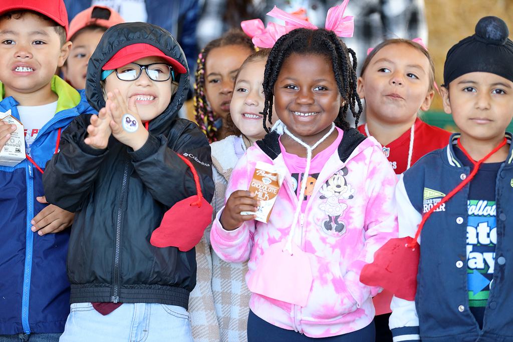 Young students smile, one holds chocolate milk