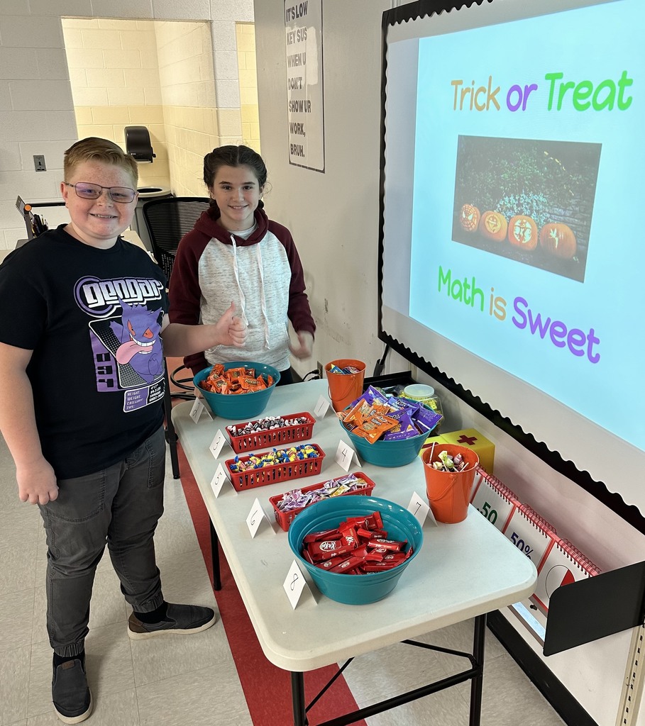 Two students select candy from a table.