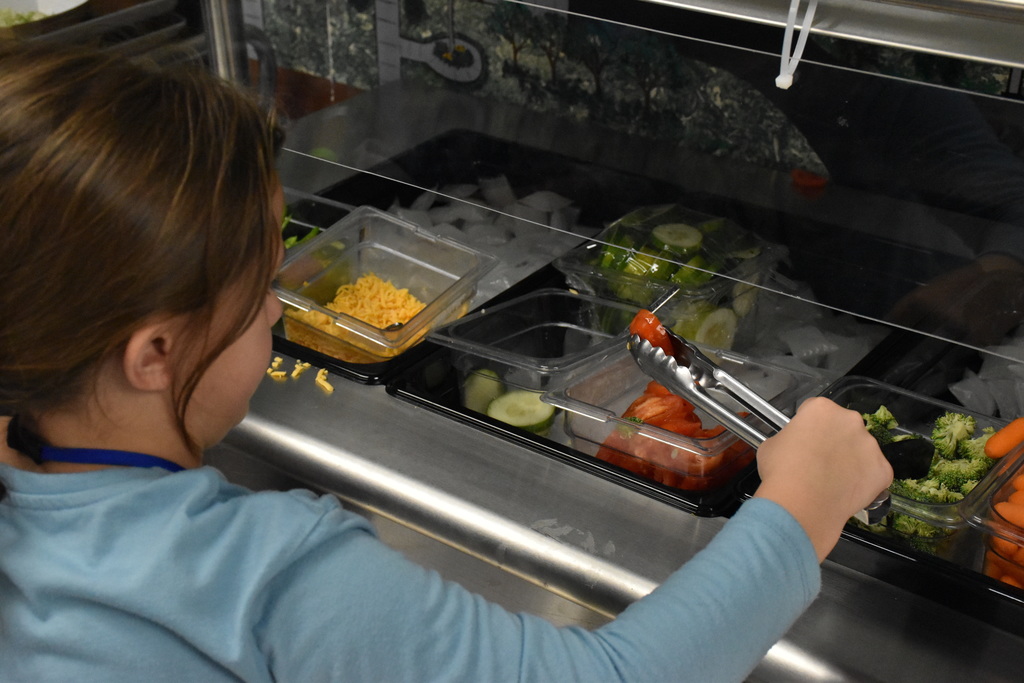 Elementary school students are pictured using the school’s new salad bar during lunch earlier this month. 