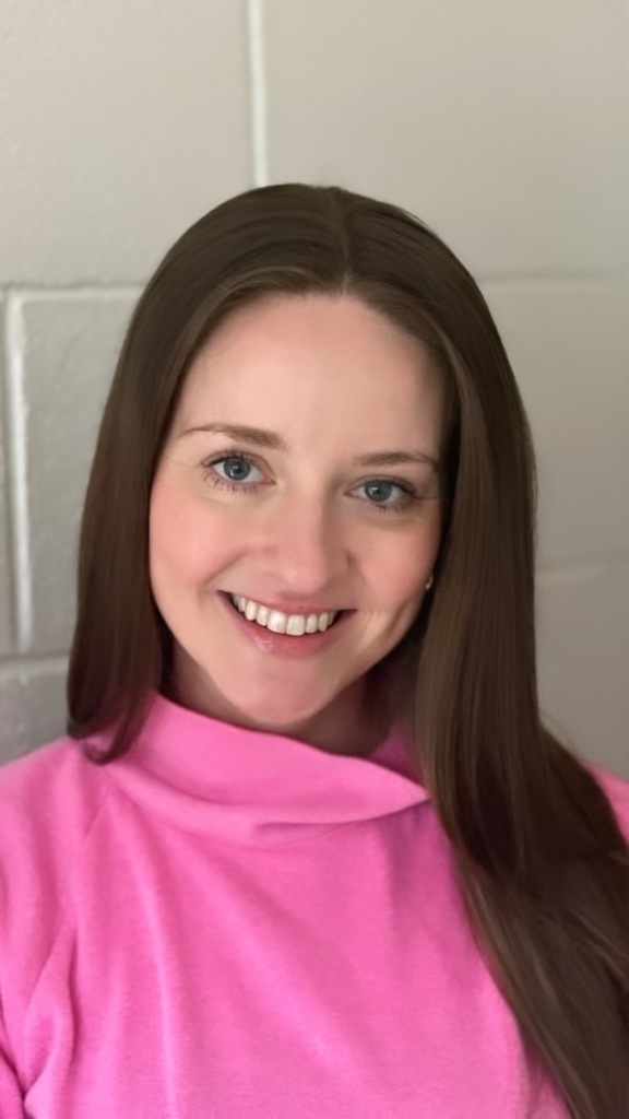 A woman smiles at the camera.