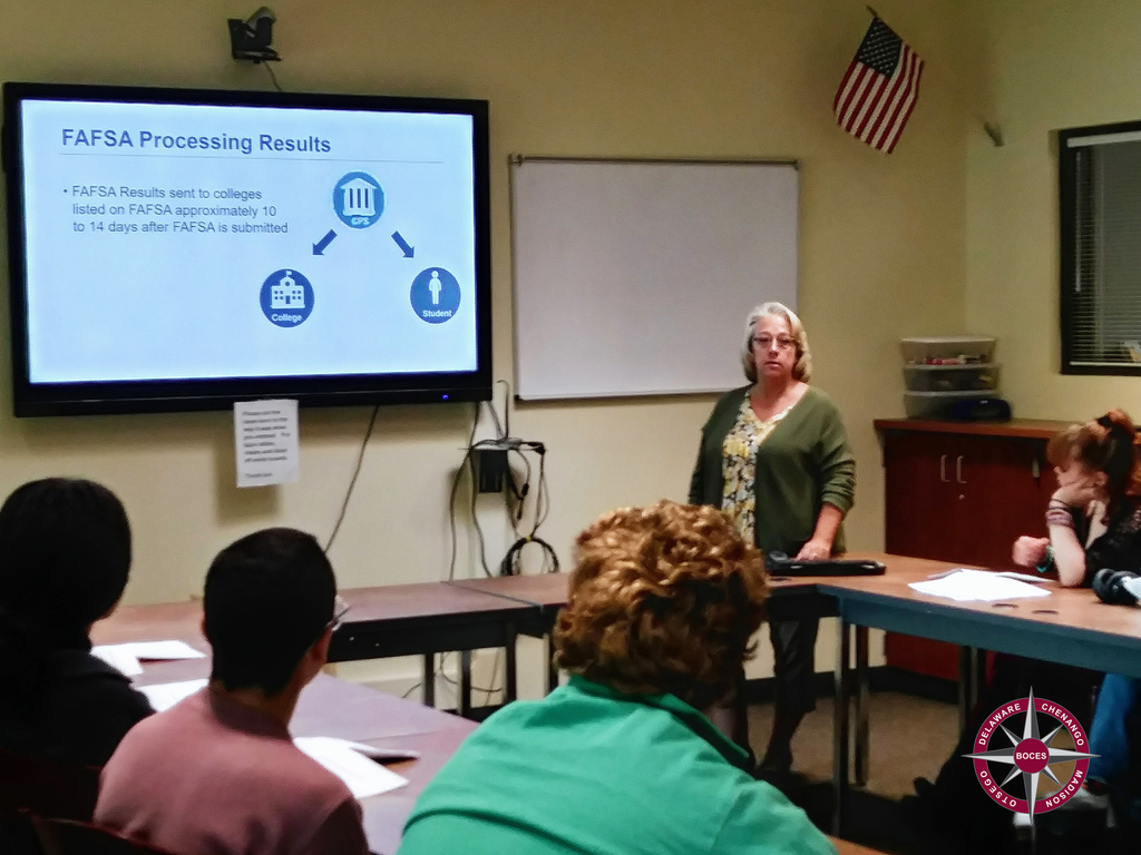 College financial aid officer presenting information to students in classroom