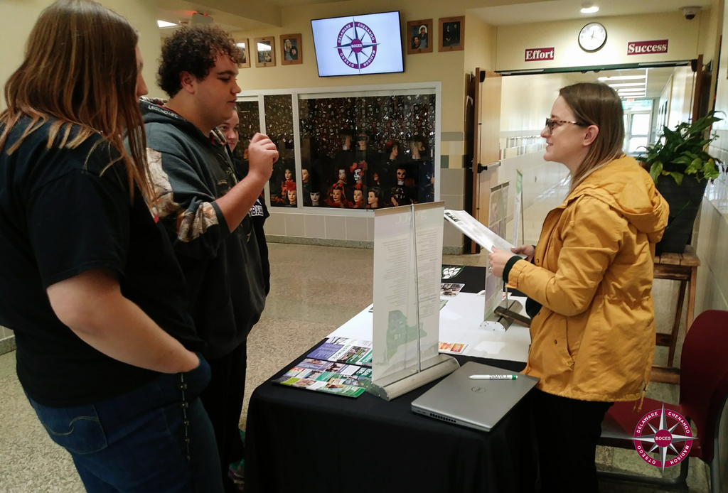 Two students speaking to a college representative