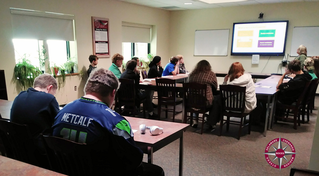 students in classroom, adult presenting financial aid information