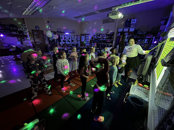A kindergarten class participates in a Glow in the dark party.