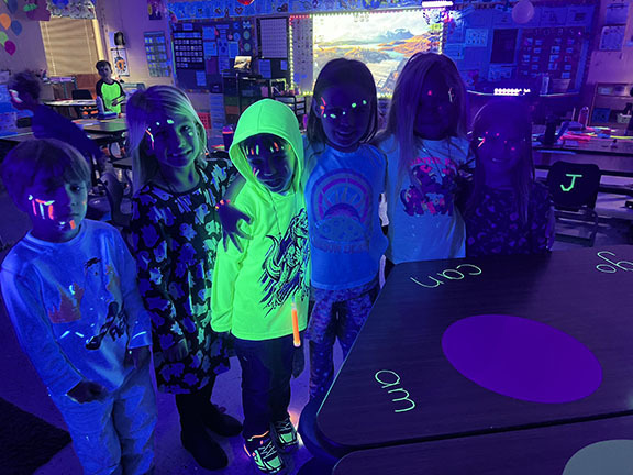A kindergarten class participates in a Glow in the dark party.