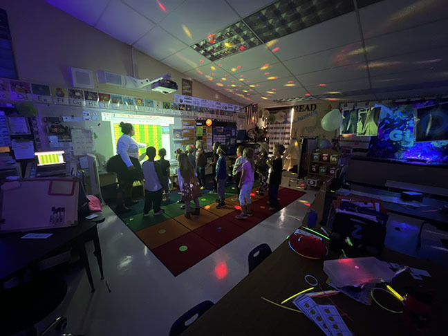 A kindergarten class participates in a Glow in the dark party.