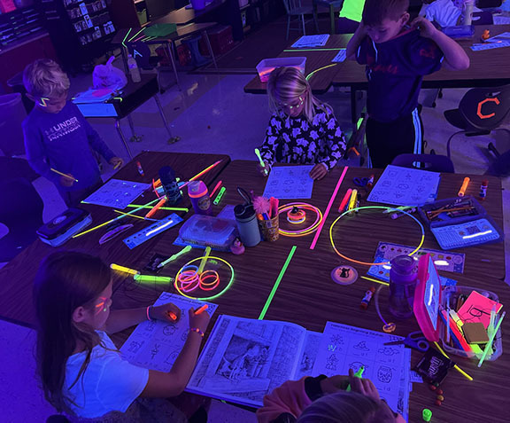 A kindergarten class participates in a Glow in the dark party.