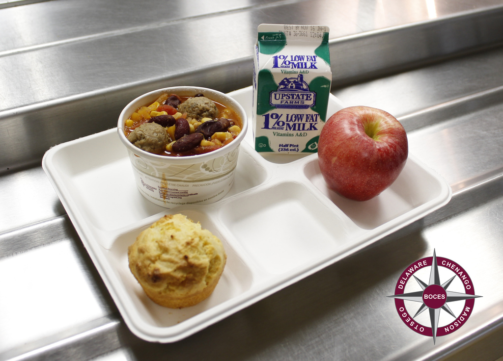photo of 3 sisters stew, cornbread muffin, milk and apple on a serving tray.