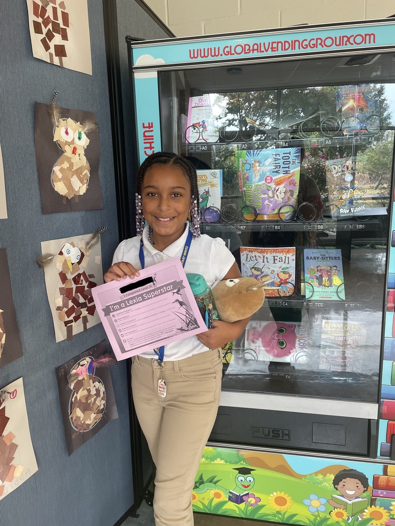 Student posing in front of book vending machine