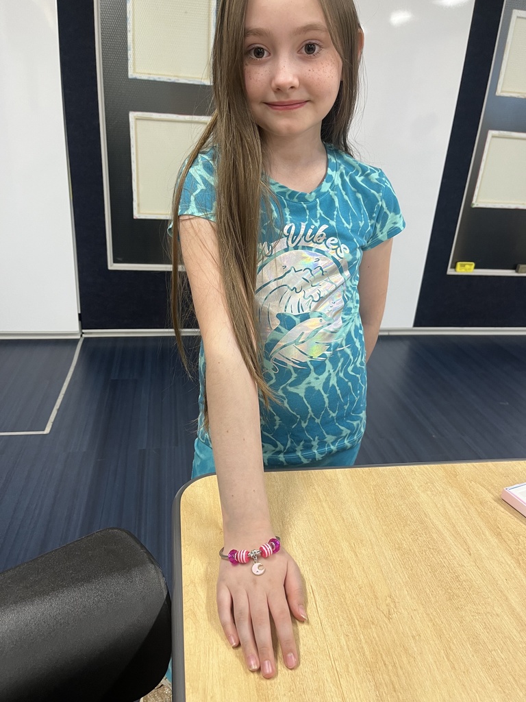 Students showing off the bracelets and necklaces they made in Jewelry Club.