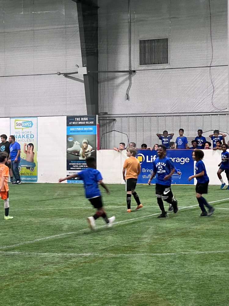 A student kicks the ball down the field