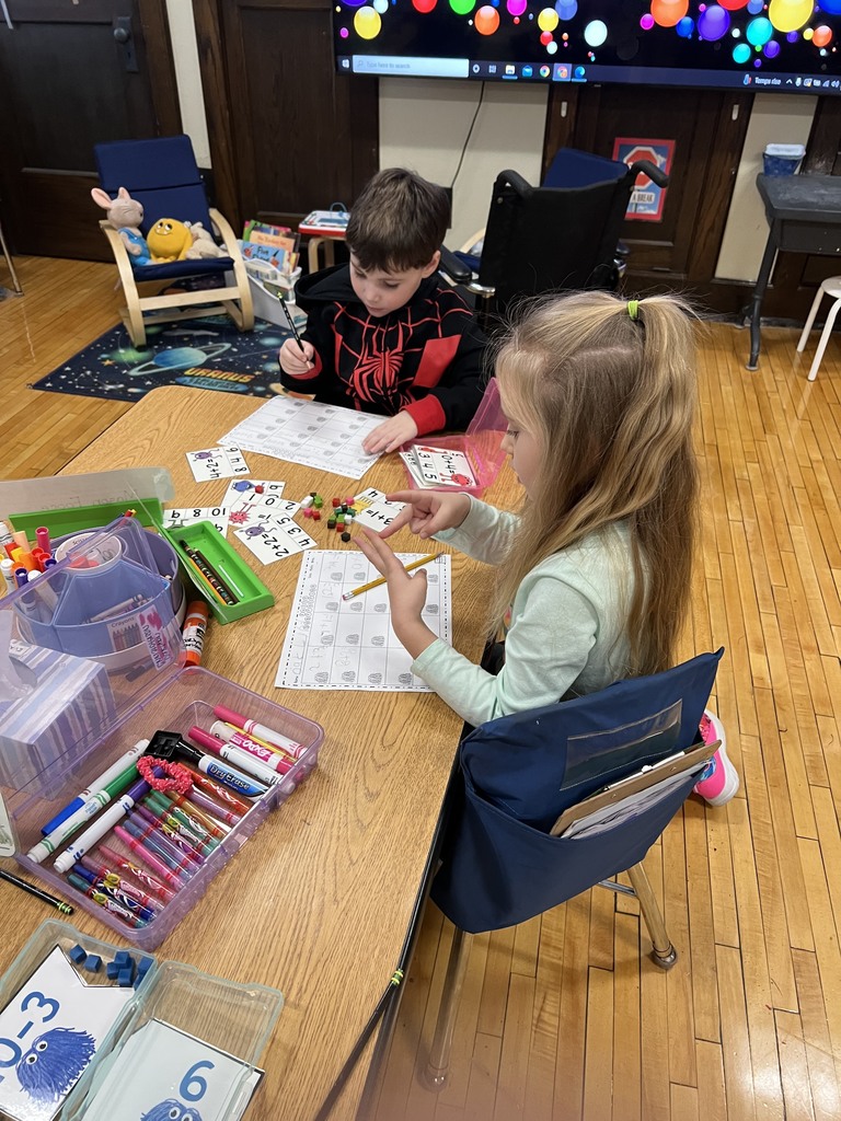 Two young students at a table doing math