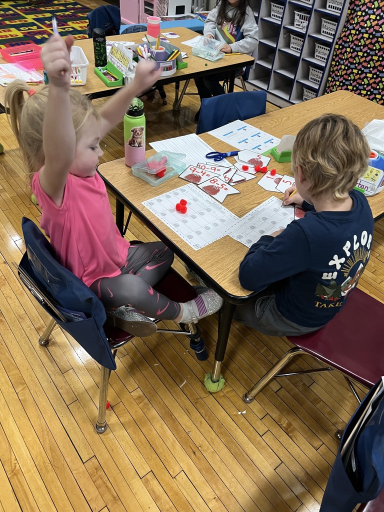 Two young students at a table doing math