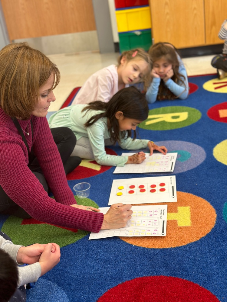 teacher explains directions for playing accounting game to the class
