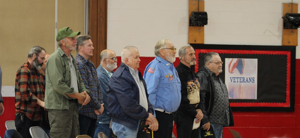 Men stand in a gym.