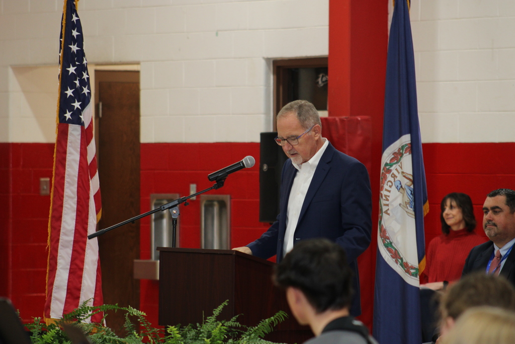 A man gives a speech in a gym.