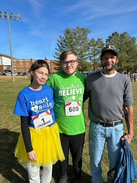 A man stands with a girl and a boy.