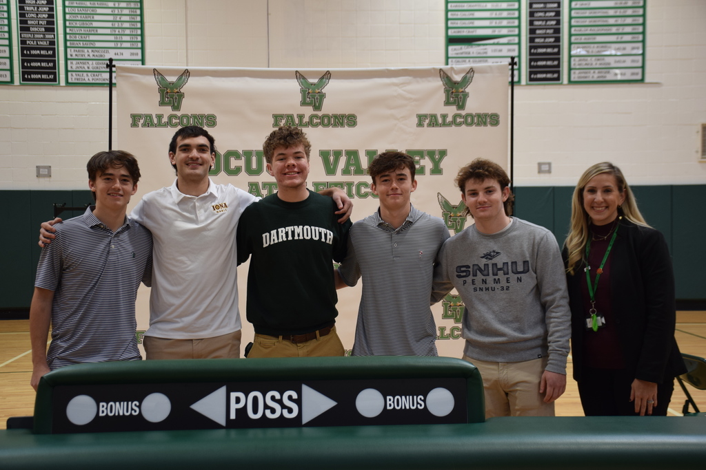 Locust Valley High School seniors Philip Terrell, Owen Hickey, Orlando Watson, Connor Terrell and Charlie Pisciotta with Athletic Director Danielle Turner Cosci after signing their letters of intent to compete in college sports on Nov. 8.