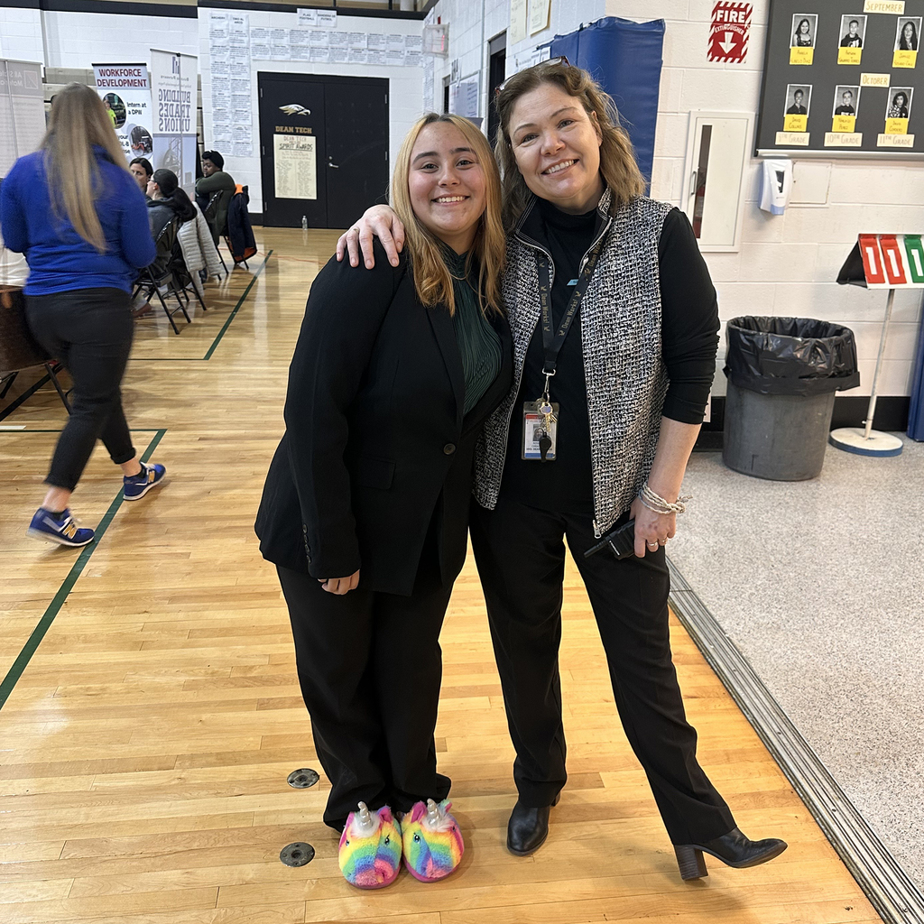 Student wearing very colorful shoes standing next to administrator