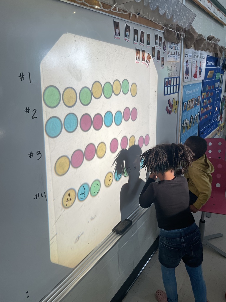 A kindergarten student labels a pattern.