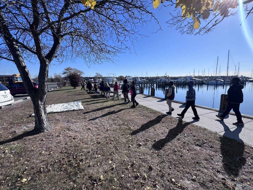 students lining up on the sidewalk by the marina