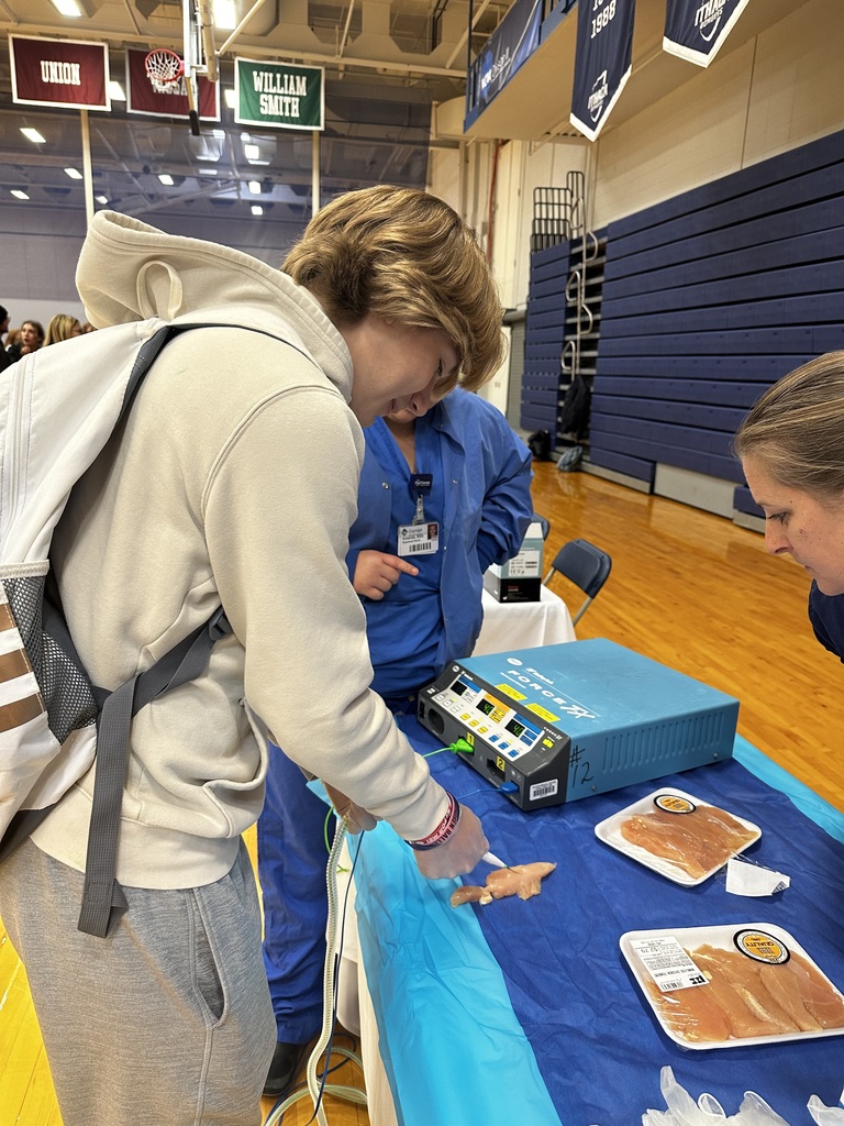 Students learning first aid with a chicken.