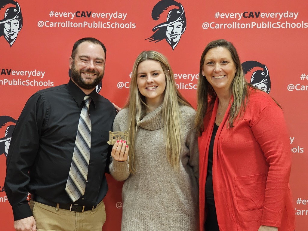 CHS principal and the varsity volleyball coaches standing in front of the branding board