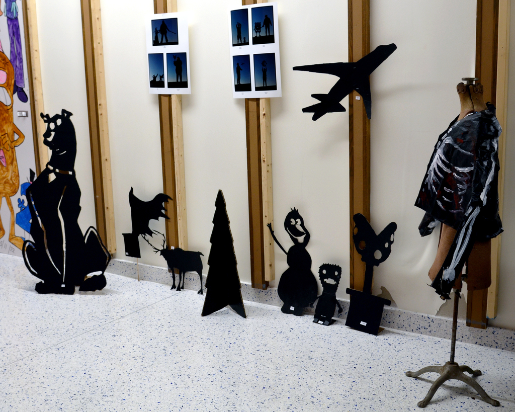 Black cut-outs of various figures and popular culture characters