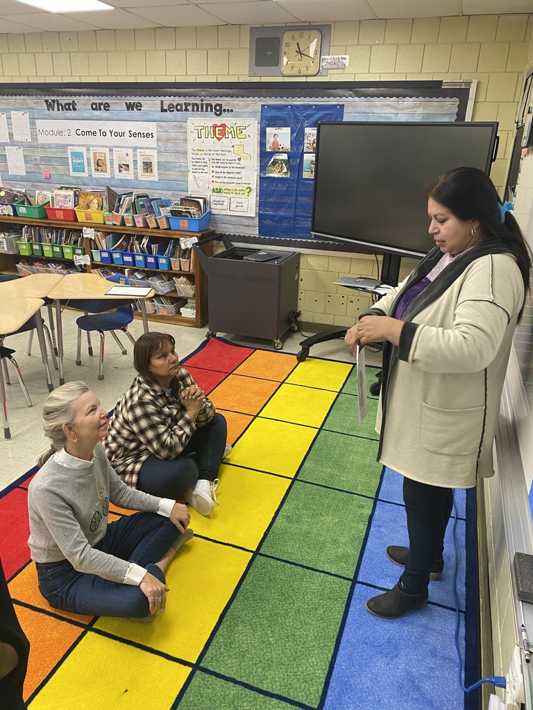 Teacher practicing lesson with two teachers seated on floor