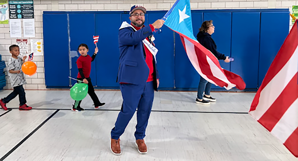 Superintendent Soto carrying Puerto Rico flag in parade