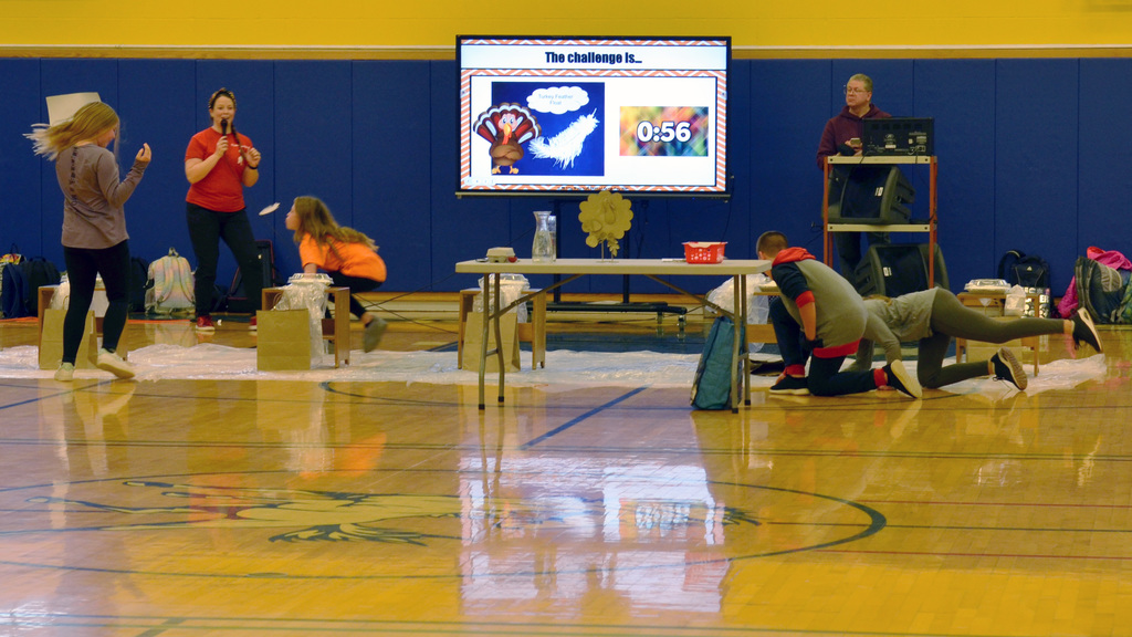 Students try to keep a feather floating in Minute-To-Win-It