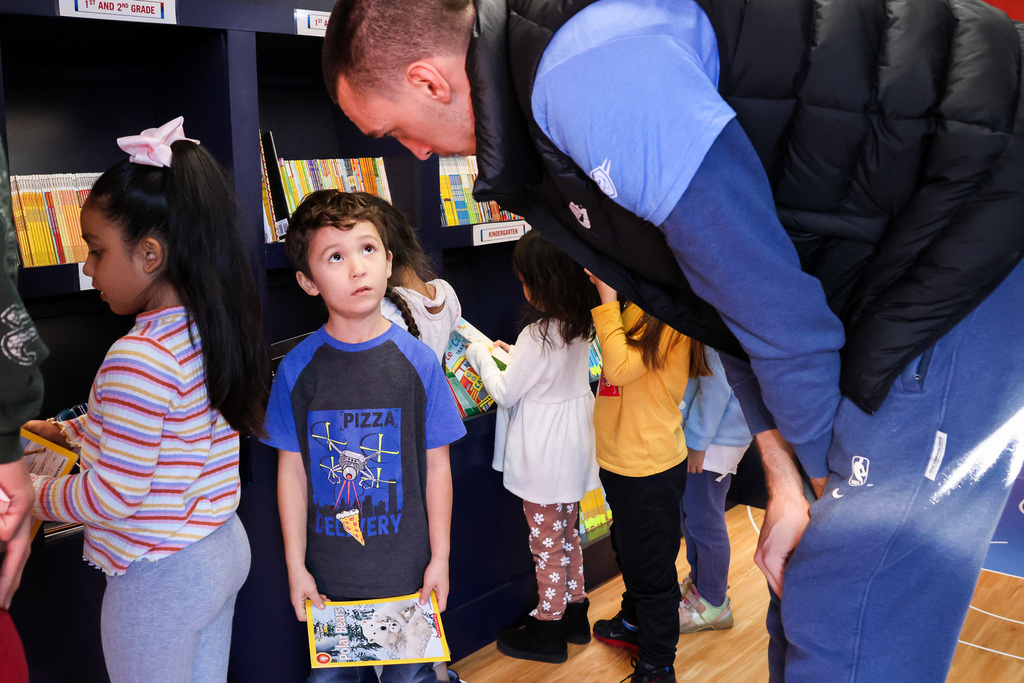 students with thunder players on book bus