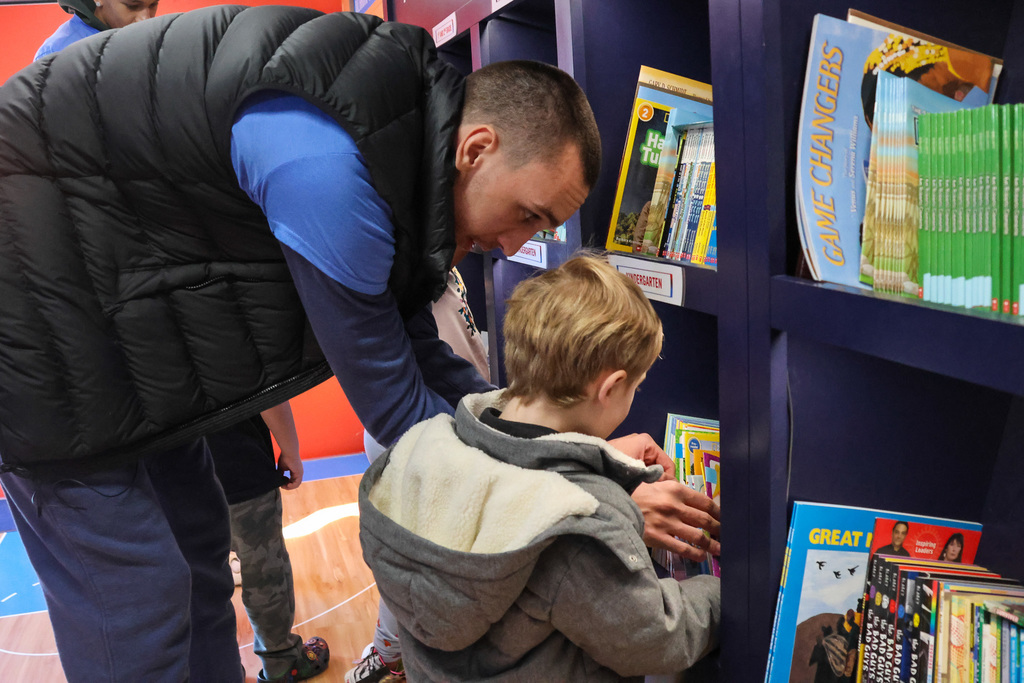 students with thunder players on book bus