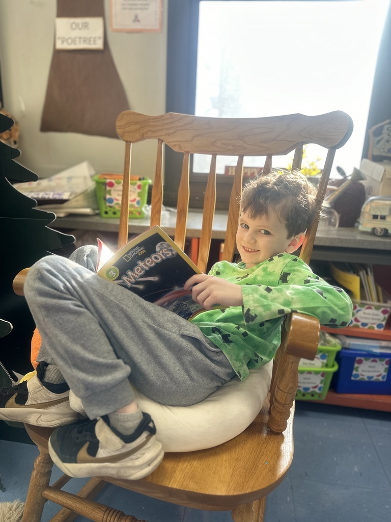 first grade student exploring book about meteors