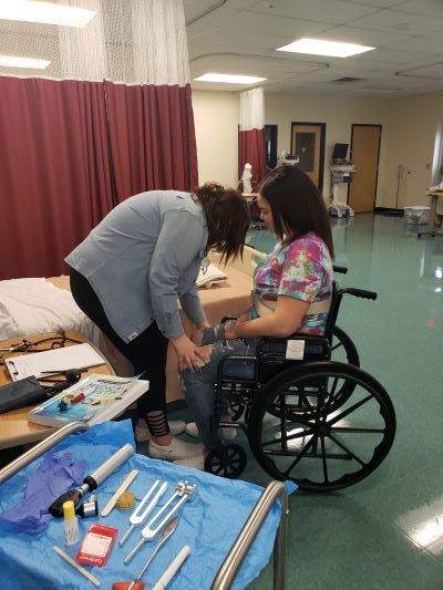 Student conducting a practice medical assessment on another student.