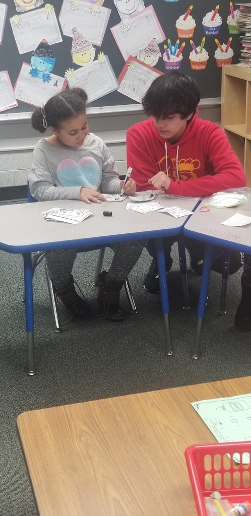 8th grade student helping a kindergarten student on her math