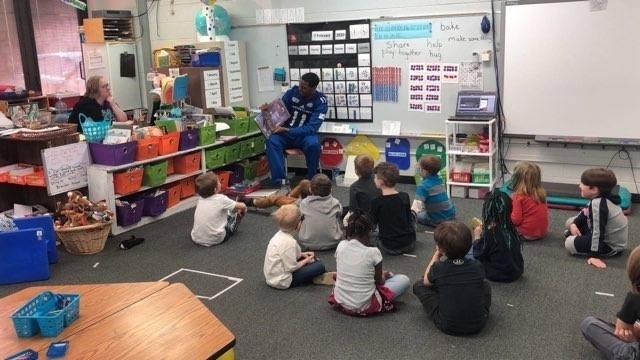 EIU fball player reading to students 