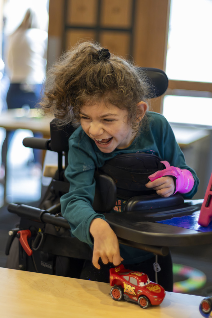 Smiling girl pushing toy car