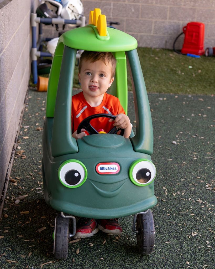Little boy driving a toy car