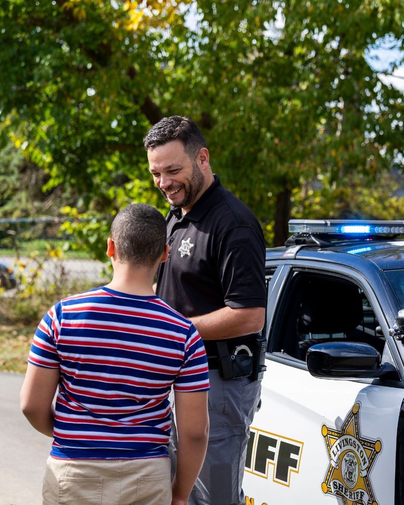 Deputy Thompson and student standing by police car.