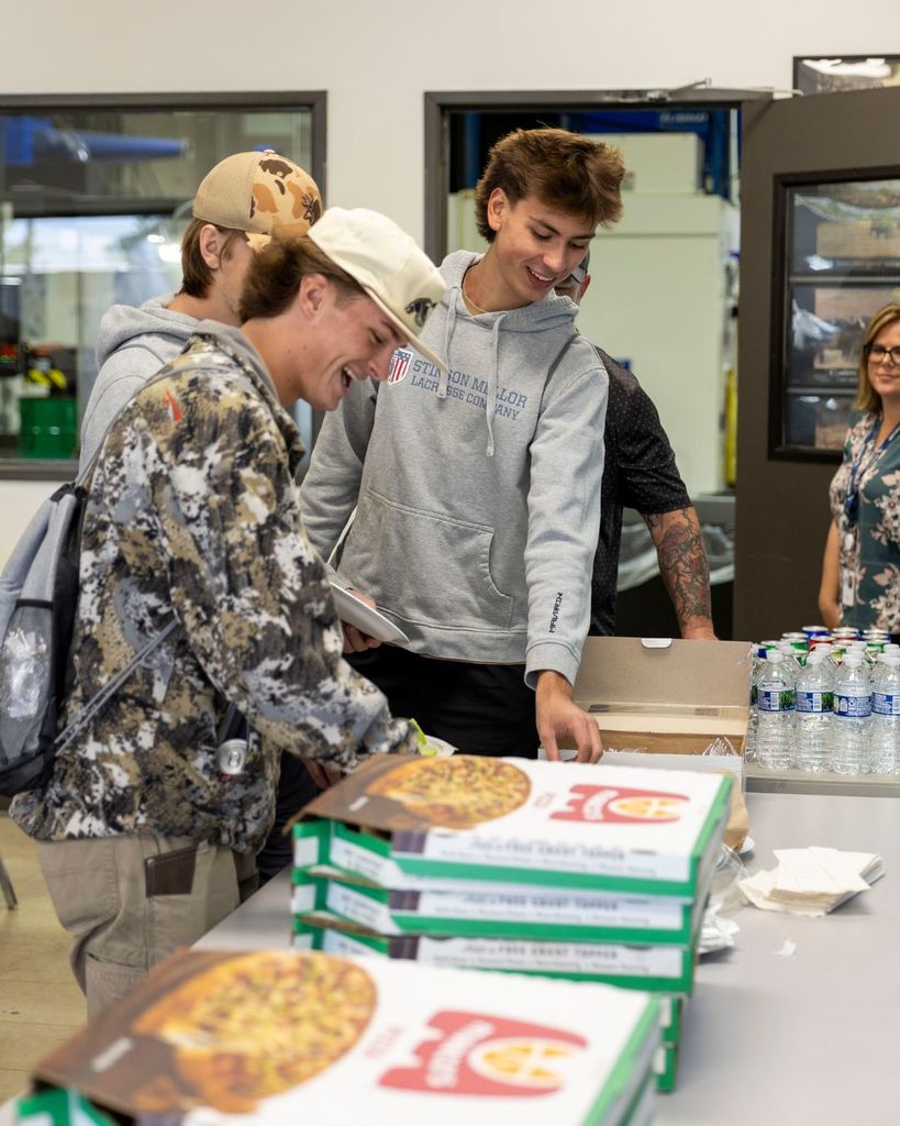 Kids smiling and getting pizza.