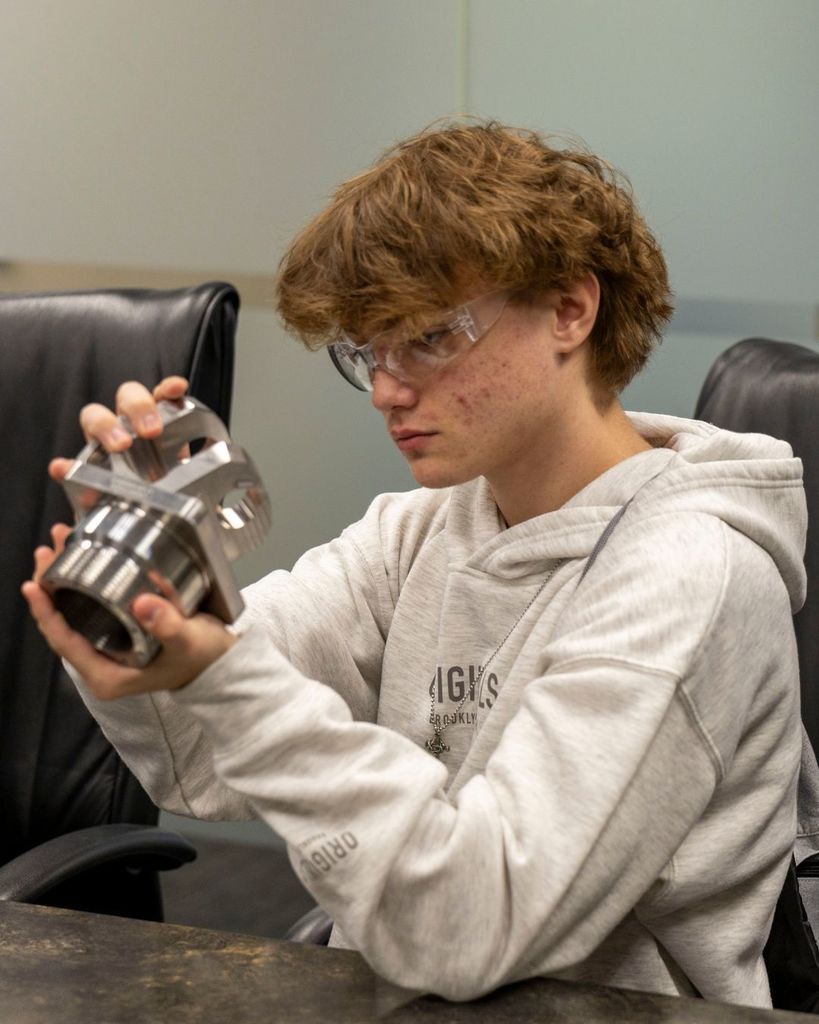 Kid looking at airplane part.
