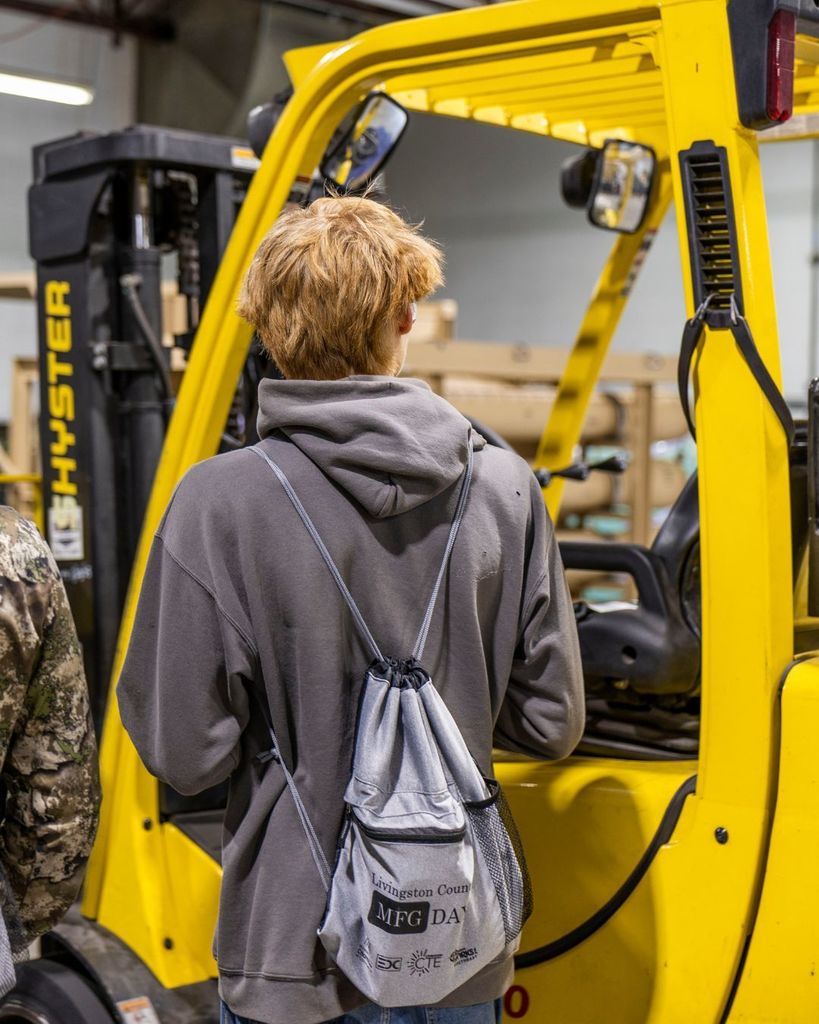 Kid looking at a piece of machinery