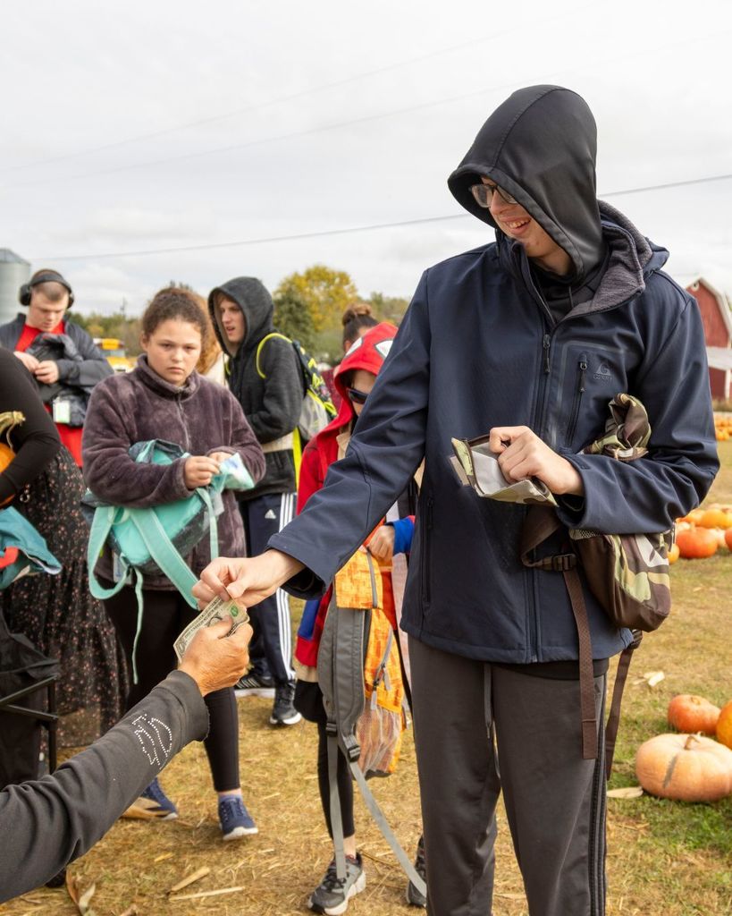 Boy handing money to shop owner.