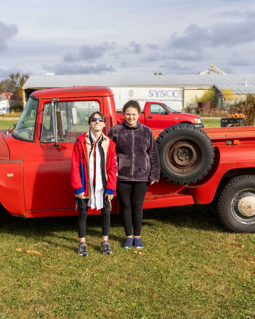 Boy and girl standing in front of vintage truck