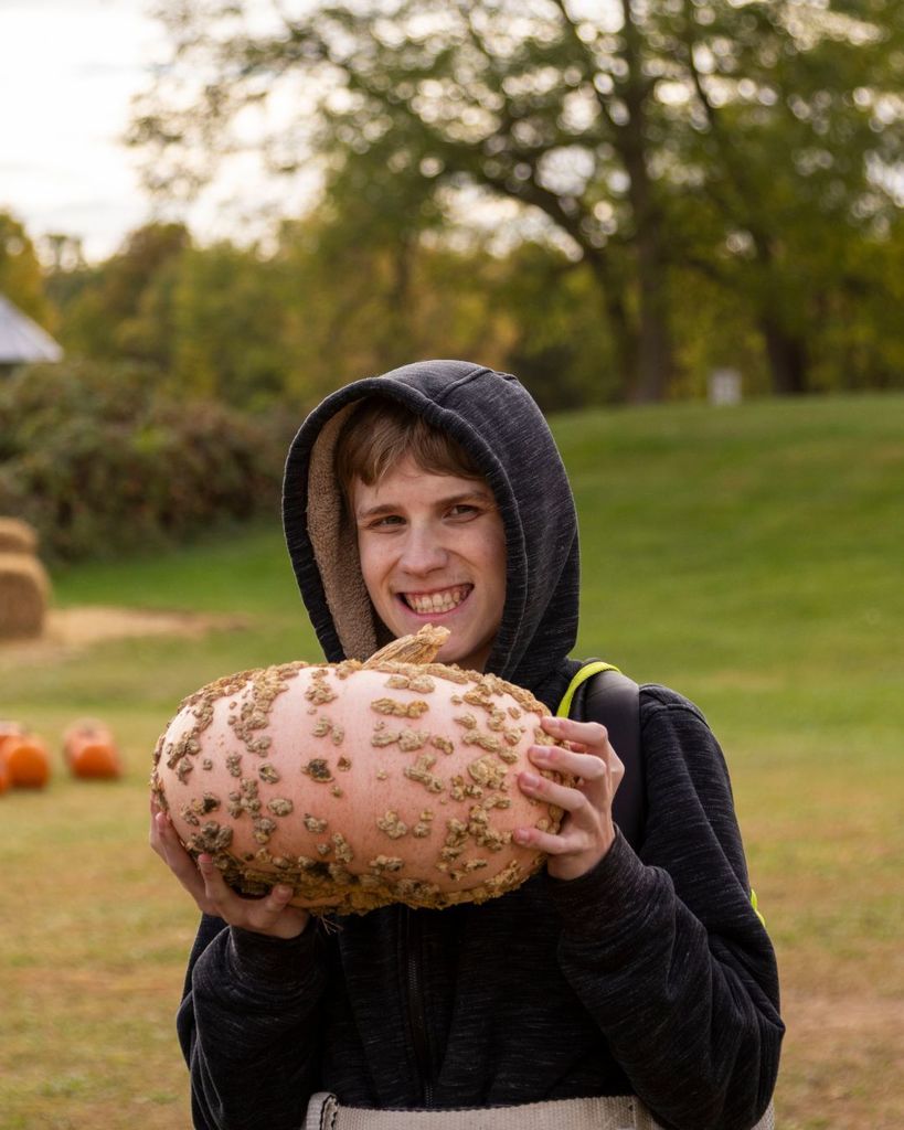Boy posing with a pumpkin