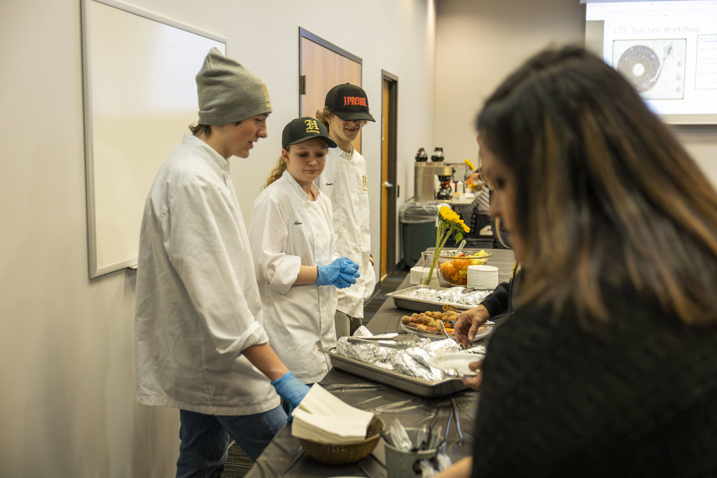 Kids serving food to adults. 