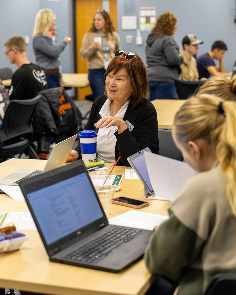 Adult talking to table to students