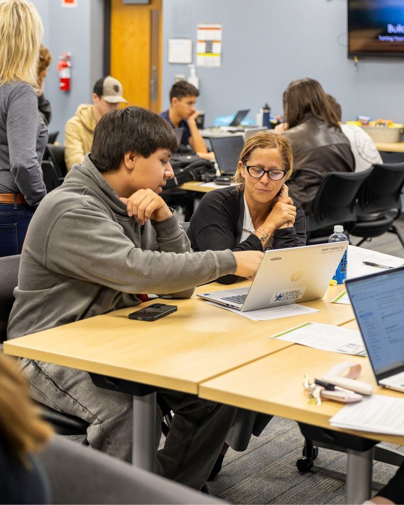 Kid and adult looking at computer