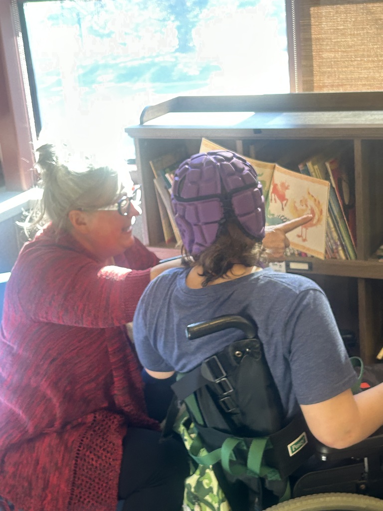Student being read a book at the library